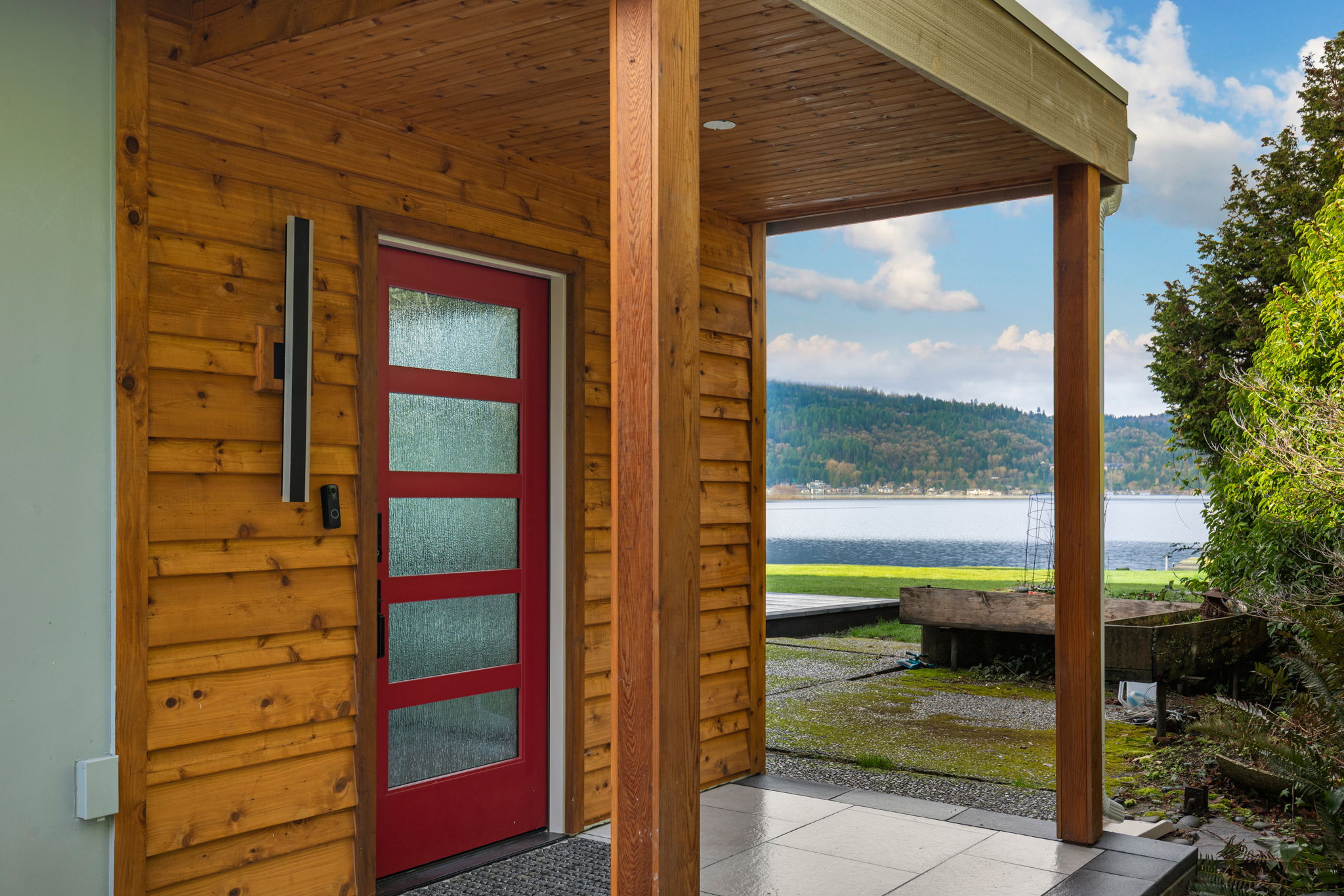 Modern home entry with cedar siding and lake view