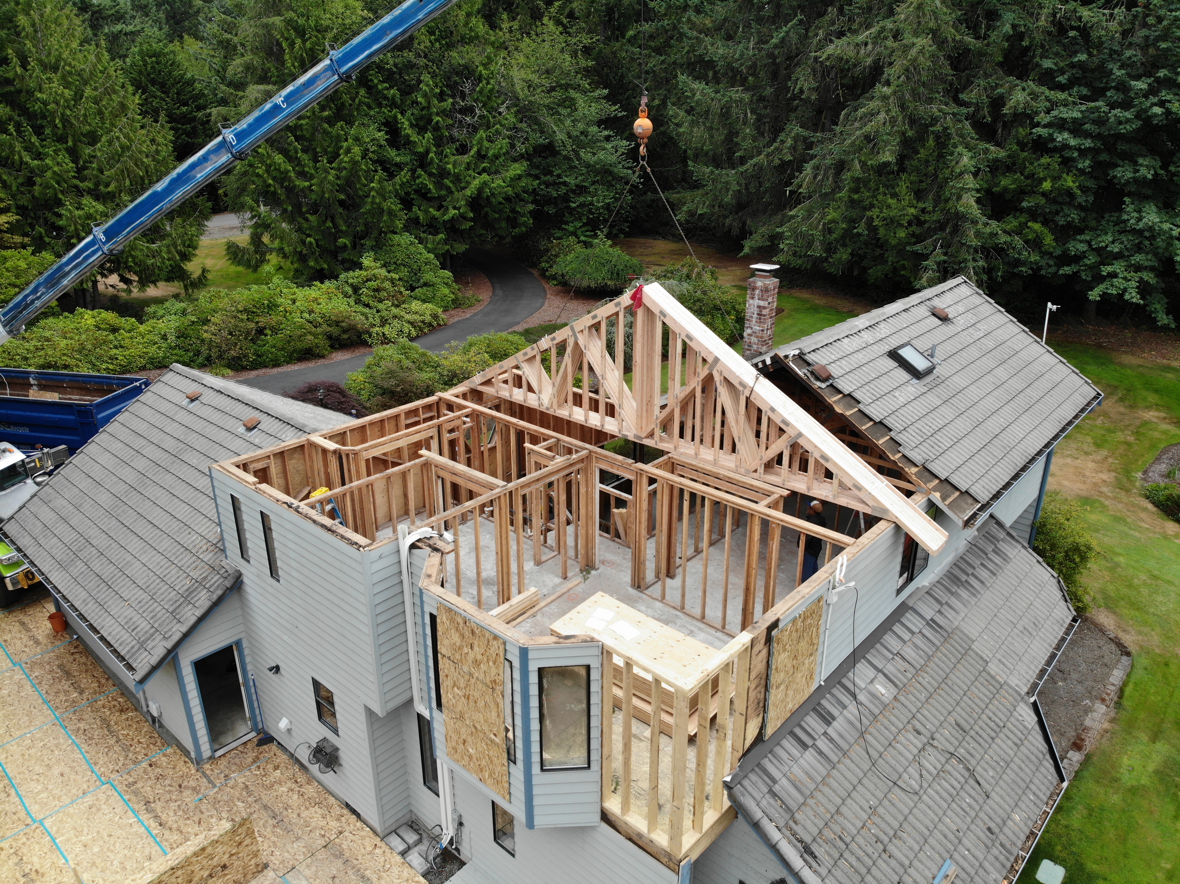 Aerial view of roof framing and truss installation with crane
